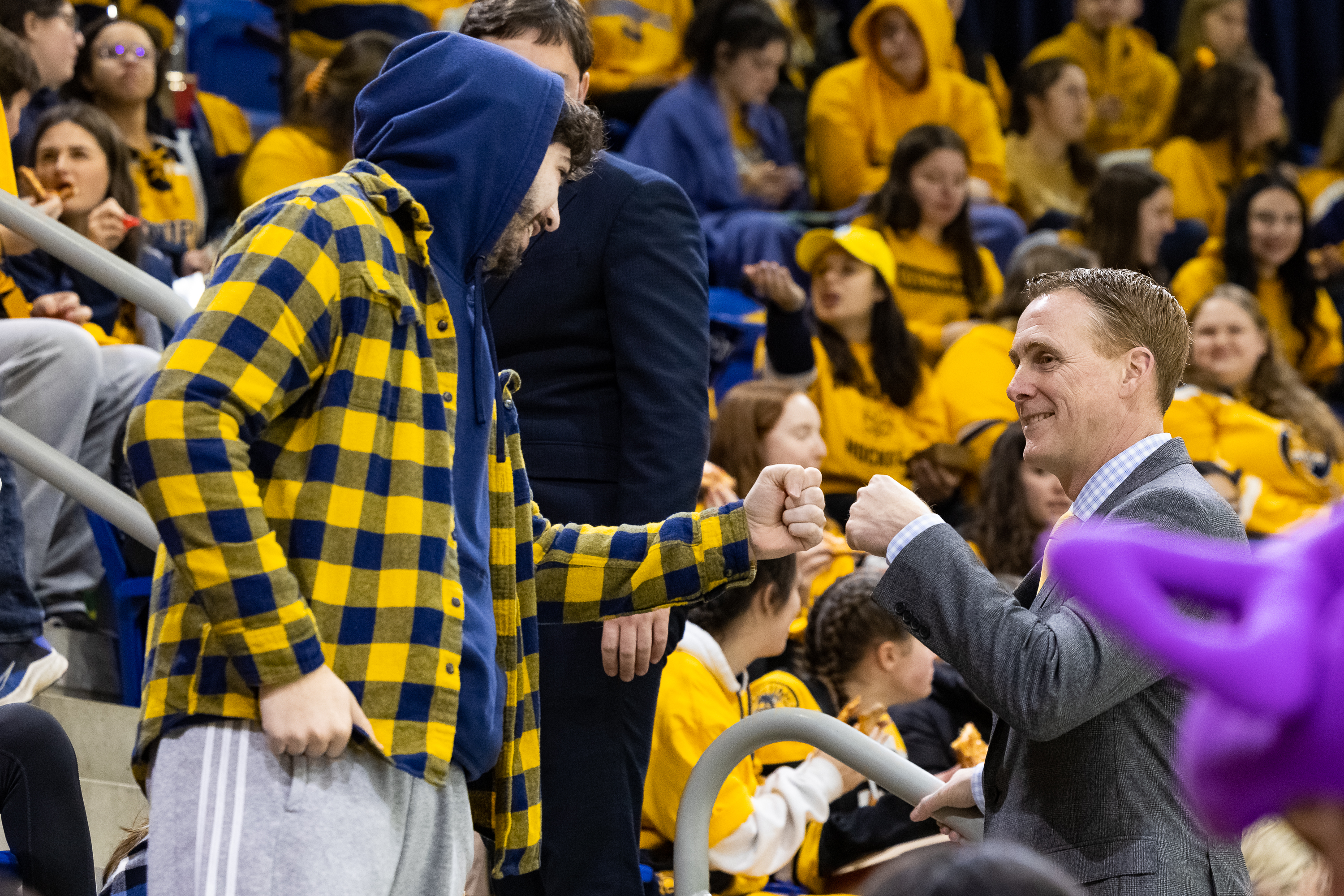 Coach Rand Pecknold steps off the bench to cheer on the team with QU students and the community.